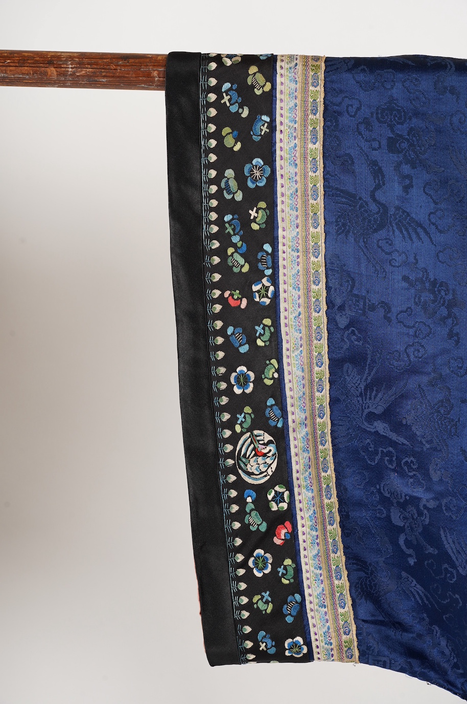 A late 19th century Chinese blue silk damask jacket, woven with Phoenix and auspicious symbols. The jacket edged with ornate rows of braiding and silk embroidery, the interior with original pink silk lining. The jacket f